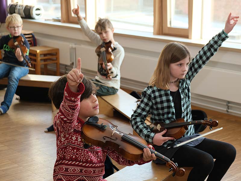 4 Grundschulkinder beim Geigenunterricht